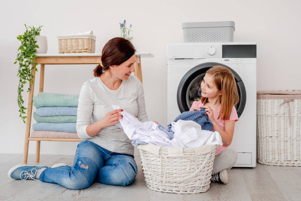 Mère avec fille tri des vêtements après la lessive - Photo, image