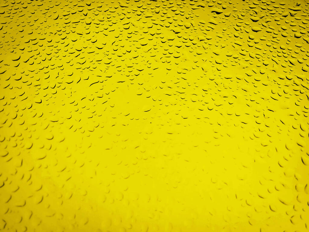 Waterdruppels op gele achtergrond, abstract shot van regendruppels op glas - Foto, afbeelding