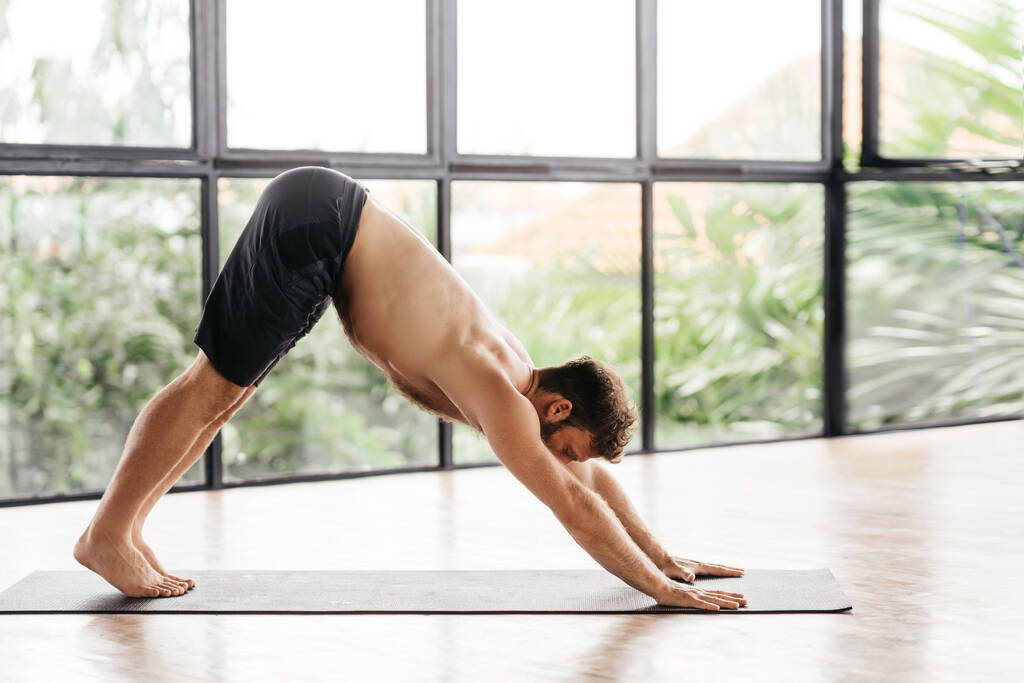Yoga men workout in studio in front of a window - Photo, Image