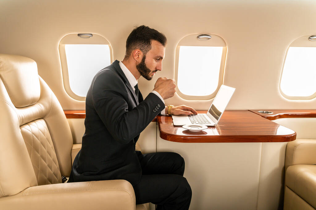 Красивий бізнесмен в елегантному костюмі, що летить на ексклюзивному приватному літаку - успішний підприємець, сидячи в ексклюзивному бізнес-класі на літаку, концепції про бізнес і транспортування
 - Фото, зображення
