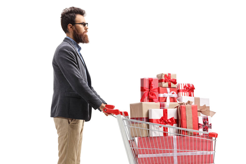 Mann mit Einkaufswagen voller Geschenke isoliert auf weißem Hintergrund - Foto, Bild