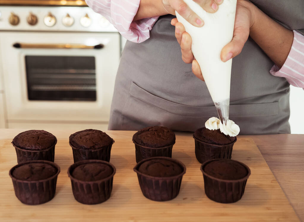 Jovem chef pastelaria mulher decora cupcakes - Foto, Imagem