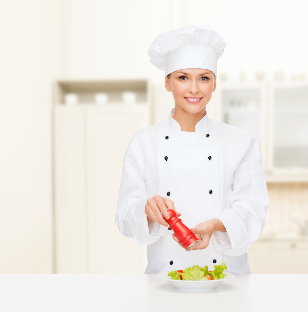 Cuoca sorridente con preparazione di insalata
 - Foto, immagini