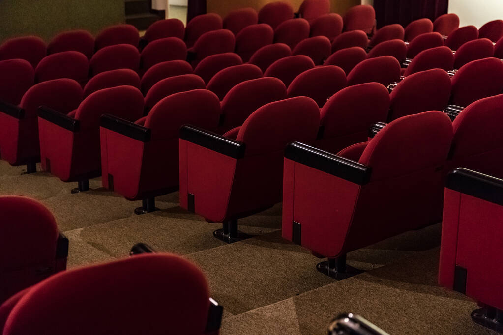 Leere rote Stühle in Reihen im Theater  - Foto, Bild
