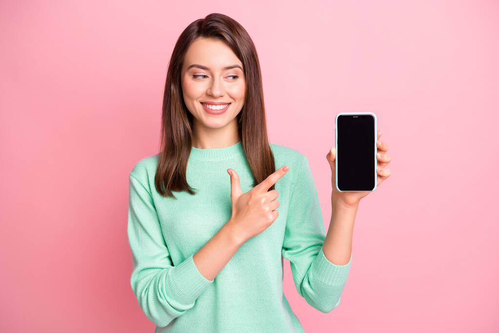Photo of lady hold telefon közvetlen ujj megjelenés képernyő üres tér kopás rózsaszín pulóver elszigetelt rózsaszín háttér - Fotó, kép
