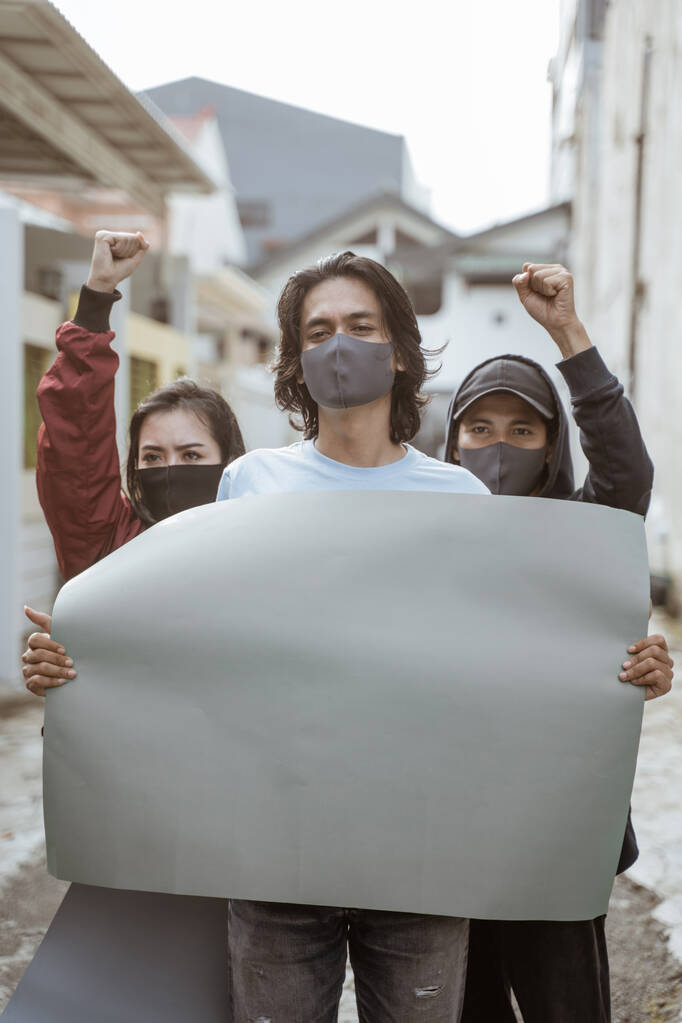 Portretstudenten met blanco papier die demonstraties geven - Foto, afbeelding