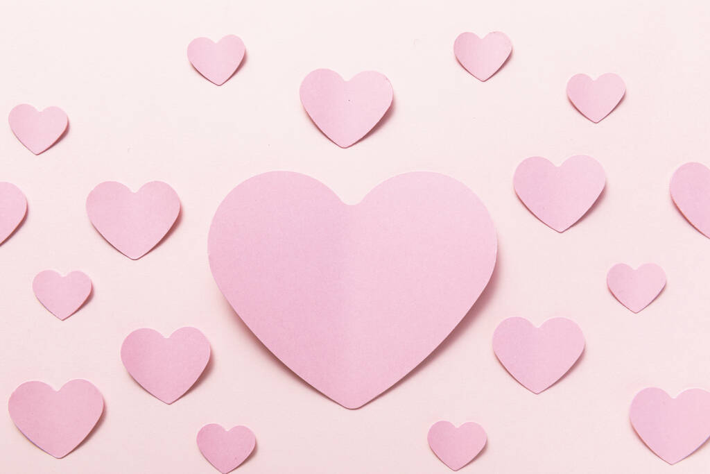 Un cliché de coeurs en papier rose avec un grand coeur au centre, le concept de Saint Valentin, texture transparente - Photo, image