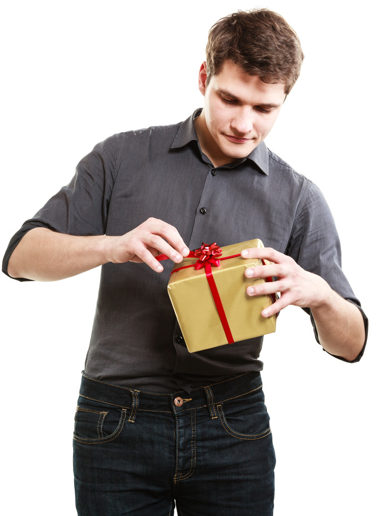 διακοπές. άνθρωπος πήρε χρυσό δώρο κουτί με κόκκινη κορδέλα - Φωτογραφία, εικόνα