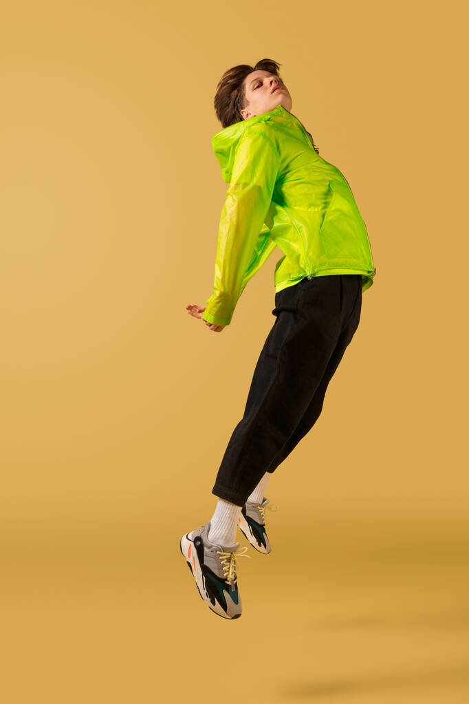 Jeune homme à l'ancienne dansant isolé sur fond jaune - Photo, image