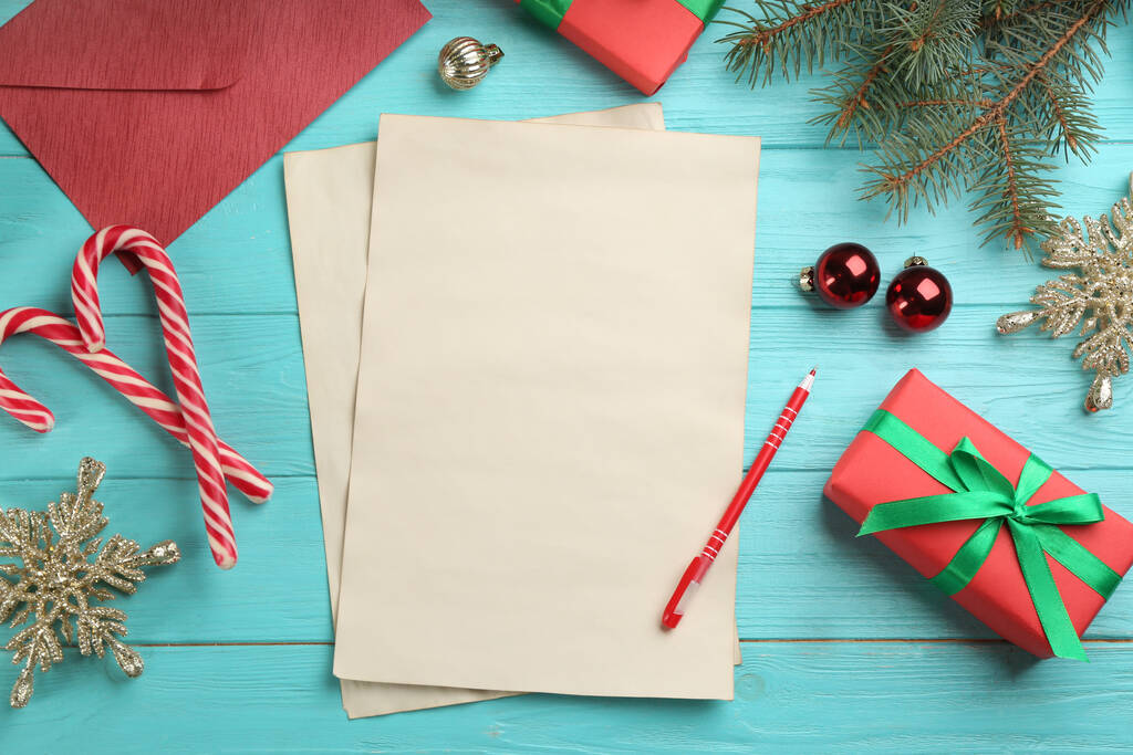 Плоский композицію з чистими аркушами паперу і різдвяними прикрасами на бірюзовому дерев'яному столі, місце для тексту. Писати листа Санті - Фото, зображення