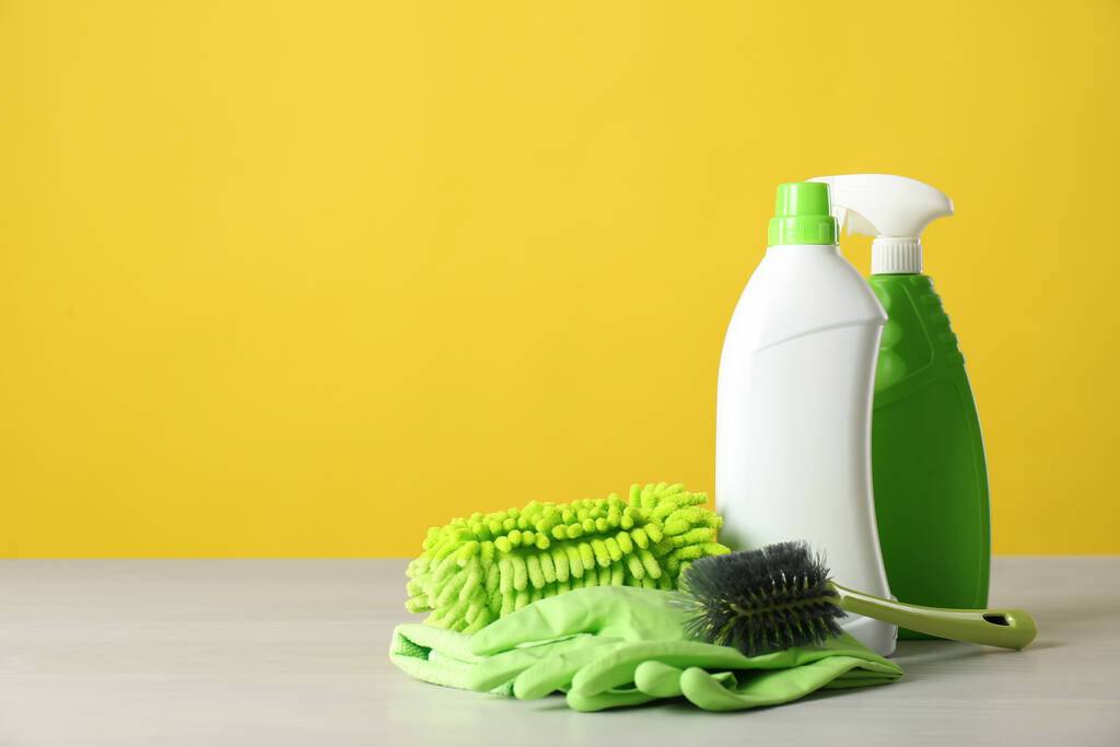 Bottles of cleaning products and supplies on light table. Space for text - Photo, Image