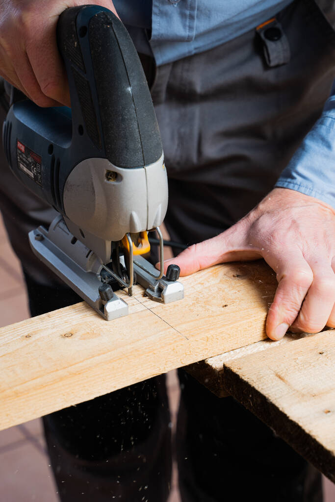 Ένα κάθετο πλάνο ενός ξυλουργού στη διαδικασία της κατασκευής ενός ξύλινου τραπεζιού - Φωτογραφία, εικόνα