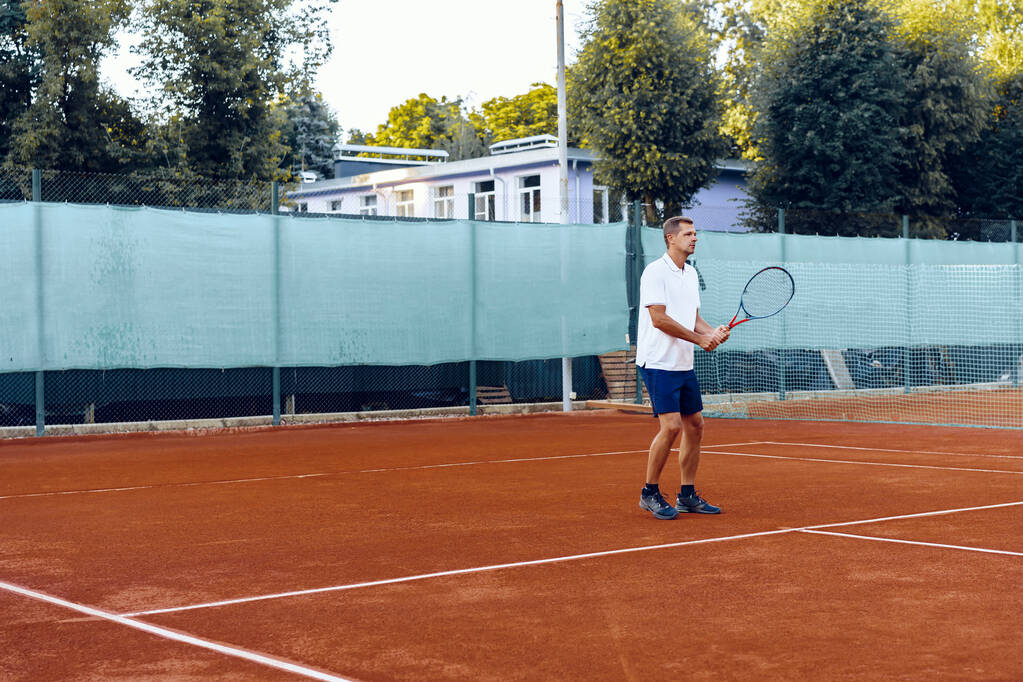 Giocatore di tennis in piedi con racchetta sul campo da tennis - Foto, immagini