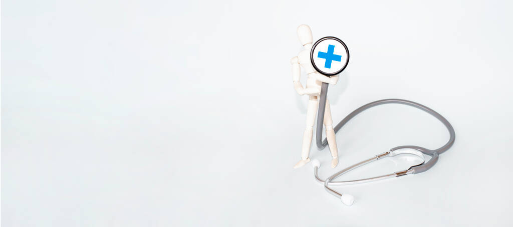 Holzfigur Mann mit Stethoskop Medizin Gesundheit auf grauem Hintergrund - Foto, Bild