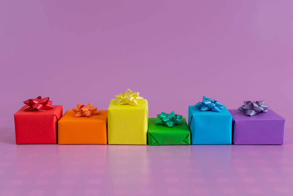 Ένα κοντινό πλάνο από κουτιά δώρων με χρώματα ουράνιο τόξο που απομονώνονται σε μωβ φόντο ιδέα κάρτα του Αγίου Βαλεντίνου - Φωτογραφία, εικόνα