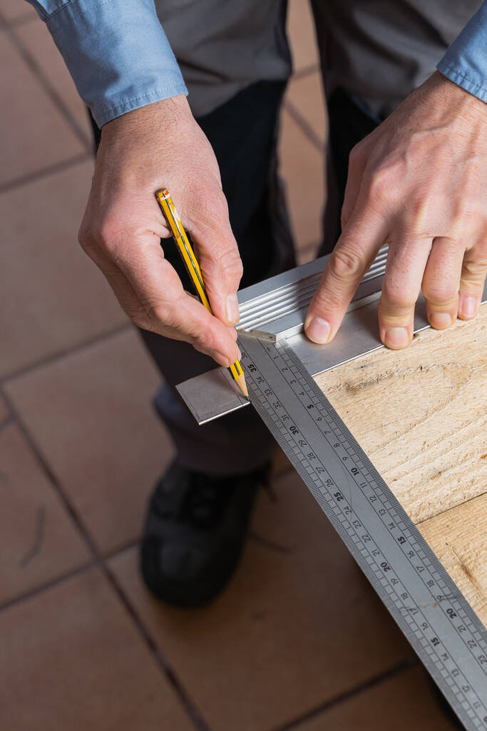Un plano vertical de un carpintero en el proceso de hacer una mesa de madera - Foto, imagen
