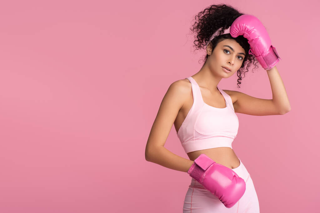 brunette woman in sportswear and boxing gloves isolated on pink  - Photo, Image