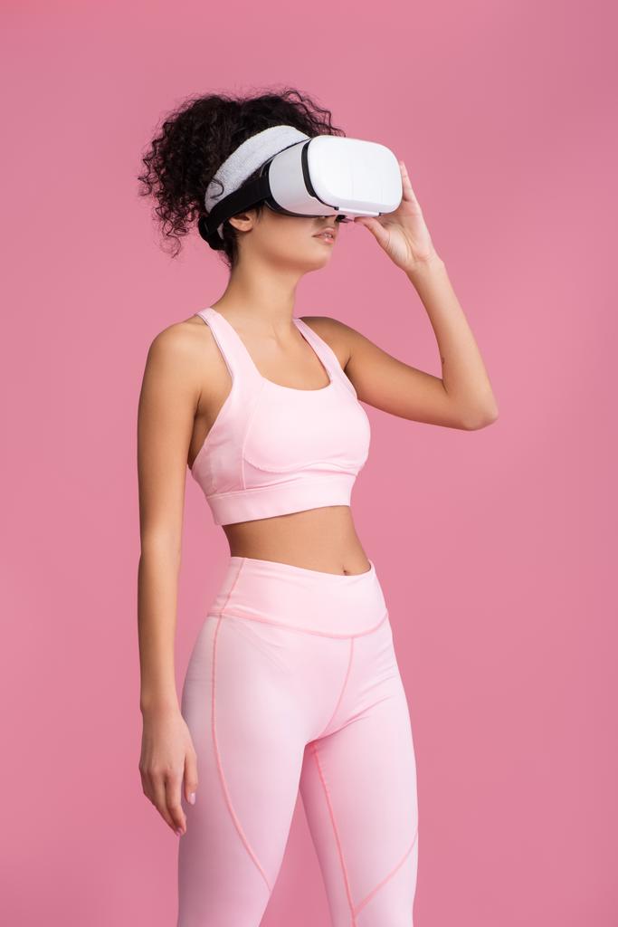 donna riccia toccando realtà virtuale auricolare isolato su rosa - Foto, immagini