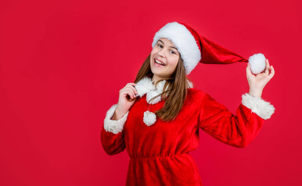 щасливий новий рік. веселого Різдва. весела дівчина-підліток святкує Різдвяну вечірку. дитина носить червоний капелюх Санта-Клауса. дитячий помічник Санти в костюмі. весело провести вечірку. готуватися до зимових канікул
 - Фото, зображення