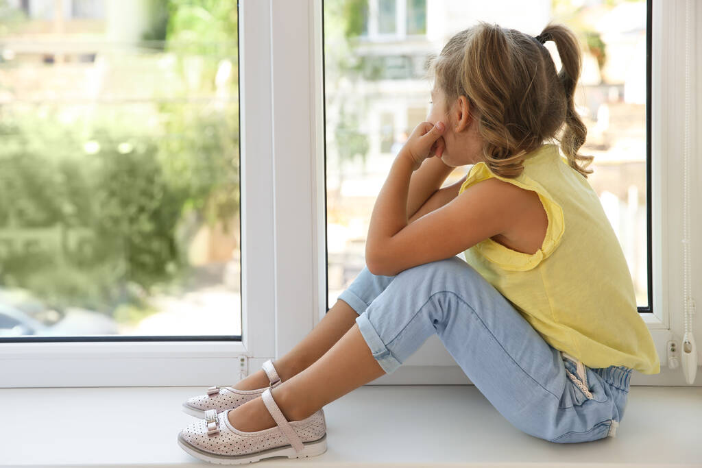 Leuk klein meisje op vensterbank thuis - Foto, afbeelding