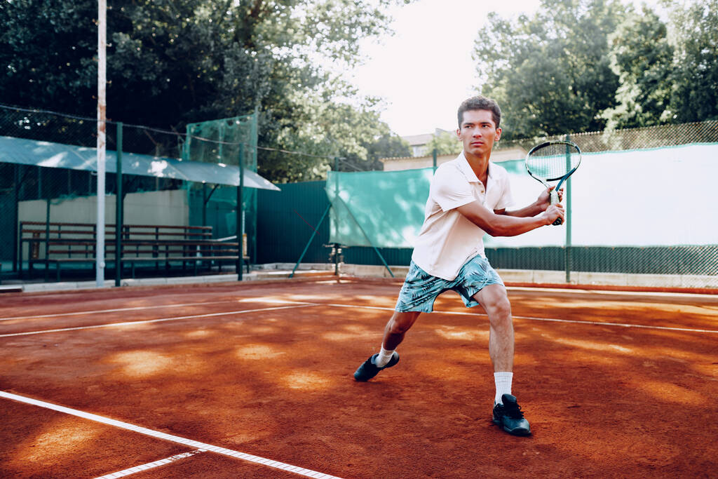 Fit mies pelaa tennistä tenniskentällä - Valokuva, kuva