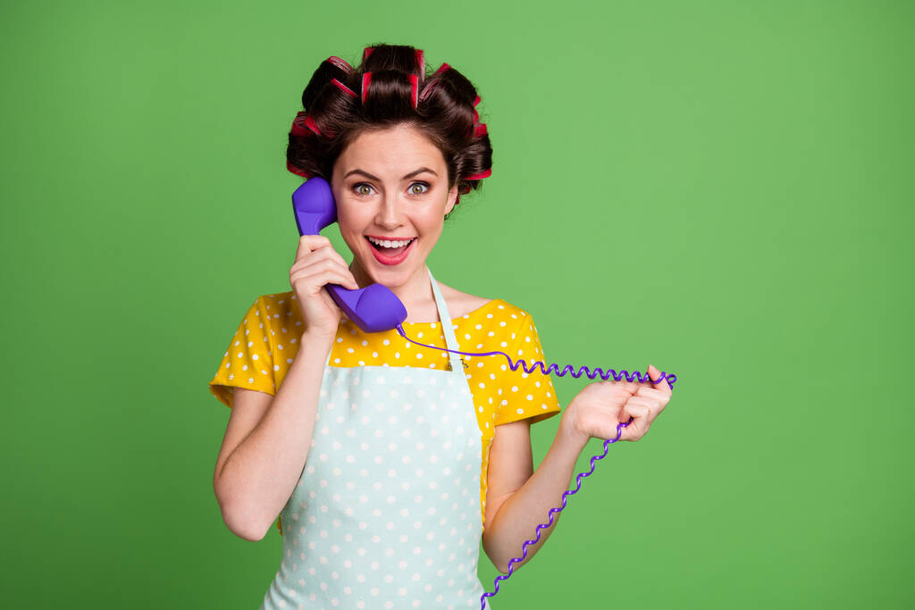 Kuva positiivinen iloinen vintage tyttö soittaa ystävä puhelinjohto nauttia karanteeni peruuttaa uutiset kulumista hiukset rullat hame eristetty vihreä väri tausta - Valokuva, kuva