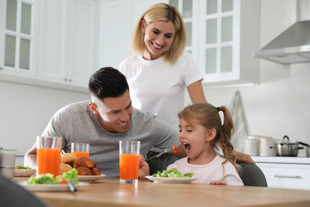 Happy family having breakfast together at table in modern kitchen - Photo, Image
