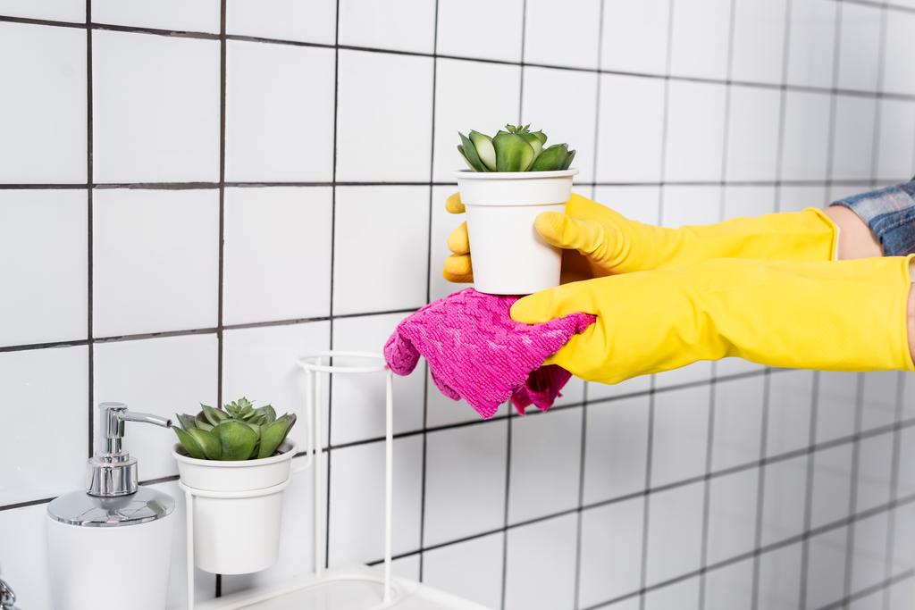 Vista recortada de mujer en planta de limpieza de guantes de goma con trapo en baño moderno  - Foto, imagen
