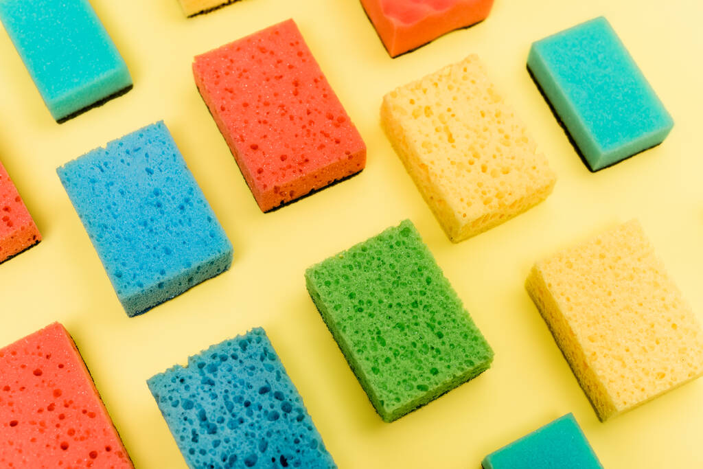 High angle view of colorful sponges on yellow background - Photo, Image