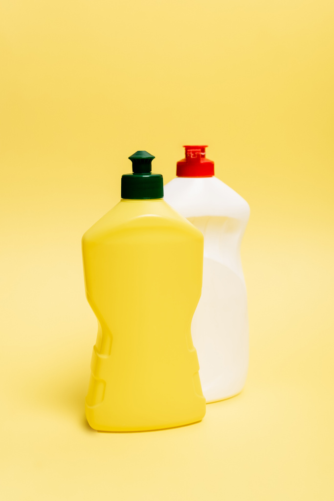 Bottiglie di liquido per piatti su fondo giallo - Foto, immagini