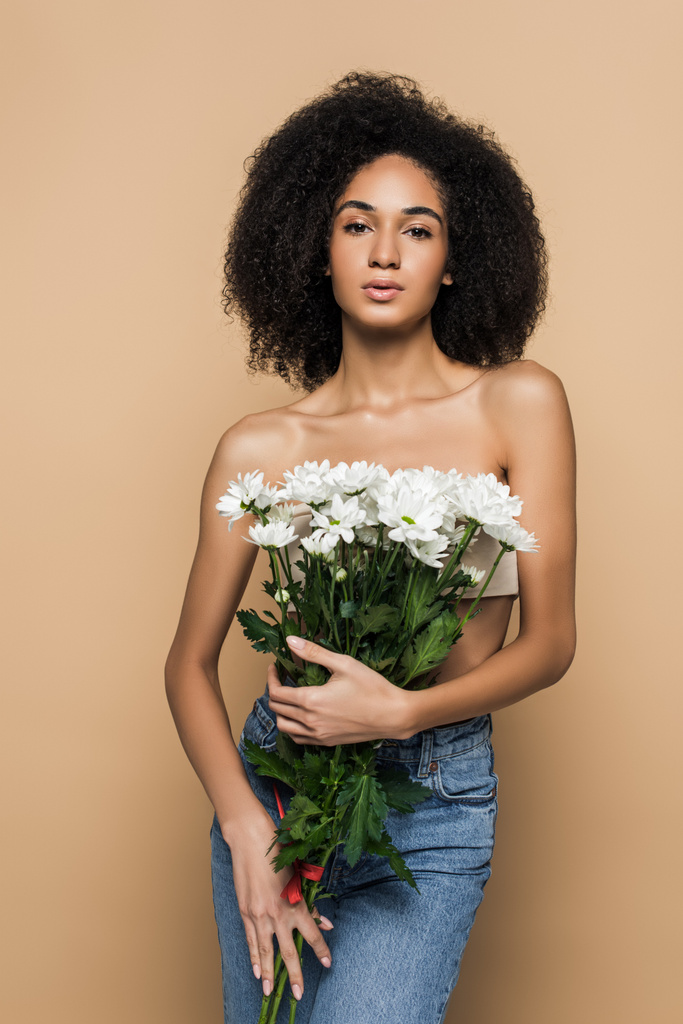 curly african american woman holding flowers isolated on beige - Photo, Image