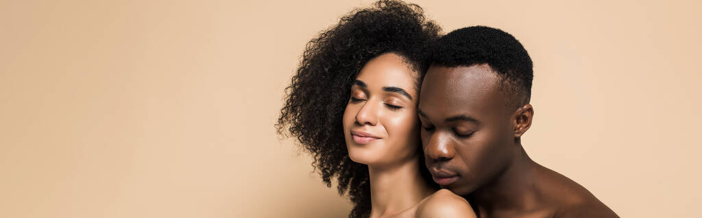 bez košile africký Američan muž blízko potěšené přítelkyně s holými rameny na béžové, prapor - Fotografie, Obrázek