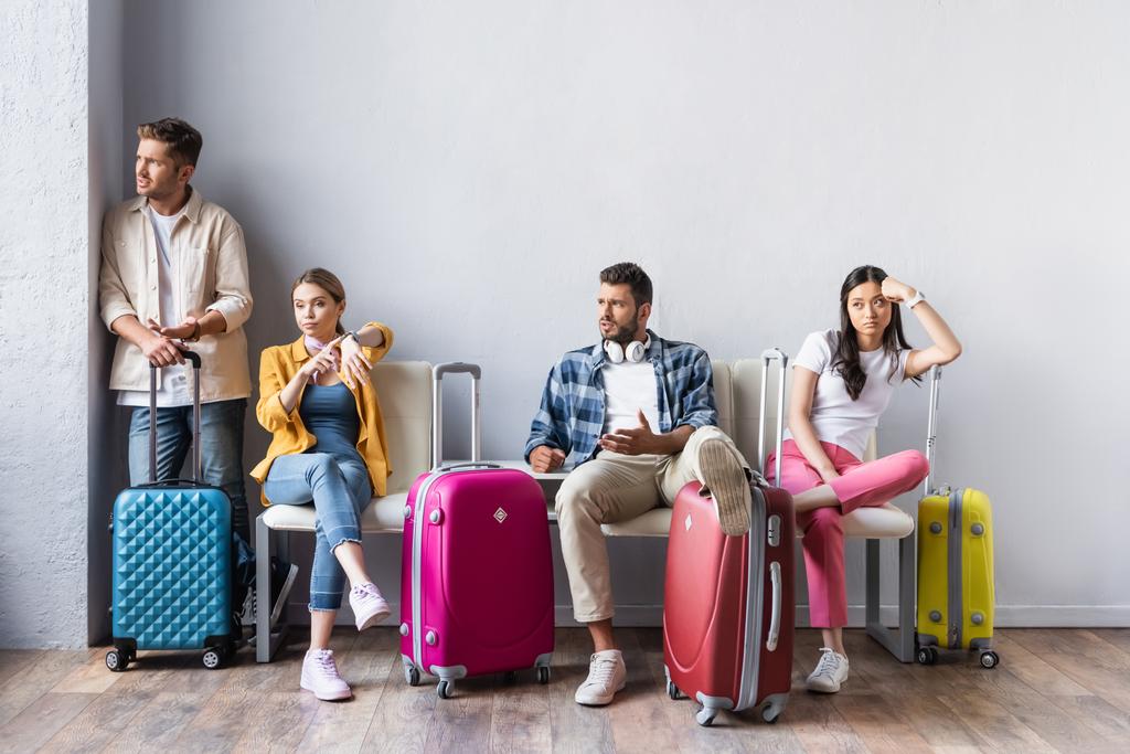 Personnes multiculturelles stressées regardant loin près des valises dans le hall de l'aéroport  - Photo, image