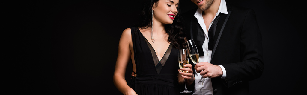 szczęśliwy para gospodarstwa kieliszki szampana izolowane na czarny, baner - Zdjęcie, obraz