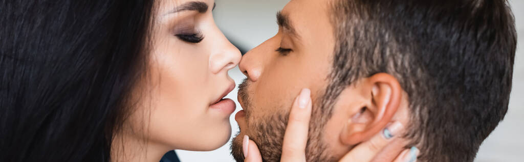 Genç bir adamın esmer bir kızı öptüğünün yan görüntüsü, afiş. - Fotoğraf, Görsel