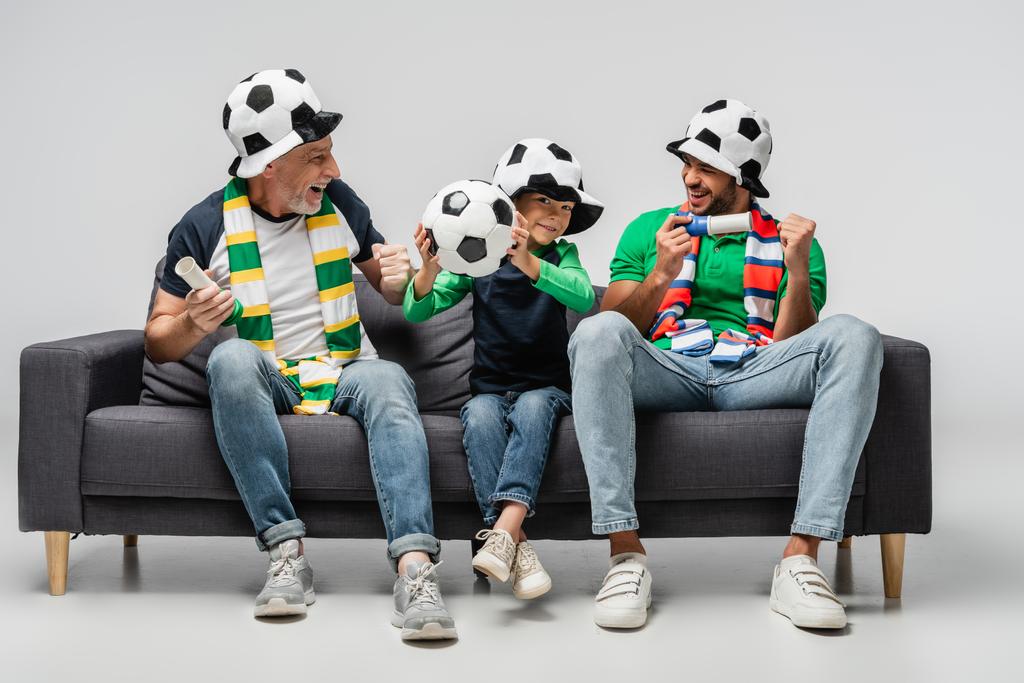 息子や孫と一緒にサッカーを見ながらウィンジェスチャーを見せる幸せな男は - 写真・画像