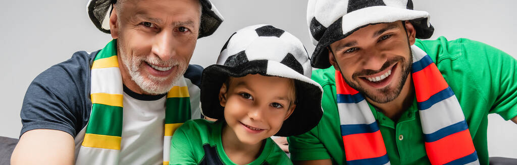 щасливі чоловіки і хлопчик у фан-капелюхах дивитися чемпіонат з футболу ізольовані на сірому, банер
 - Фото, зображення
