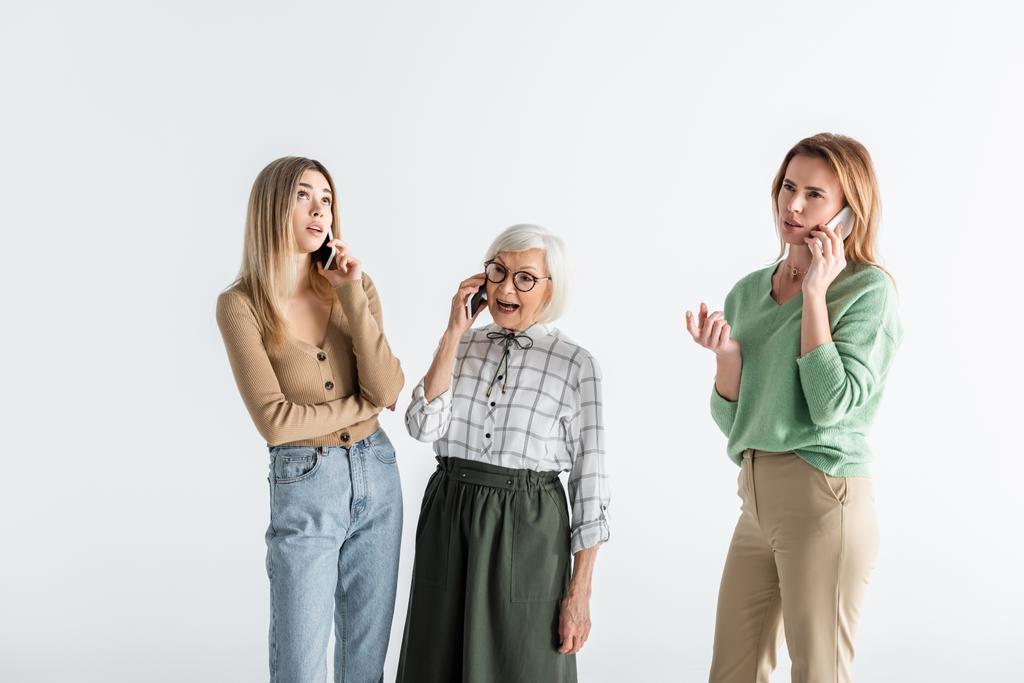 trois générations de femmes parlent sur des smartphones isolés sur blanc - Photo, image