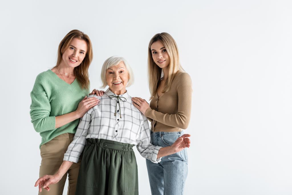 tři generace potěšených žen při pohledu na kameru izolované na bílém - Fotografie, Obrázek