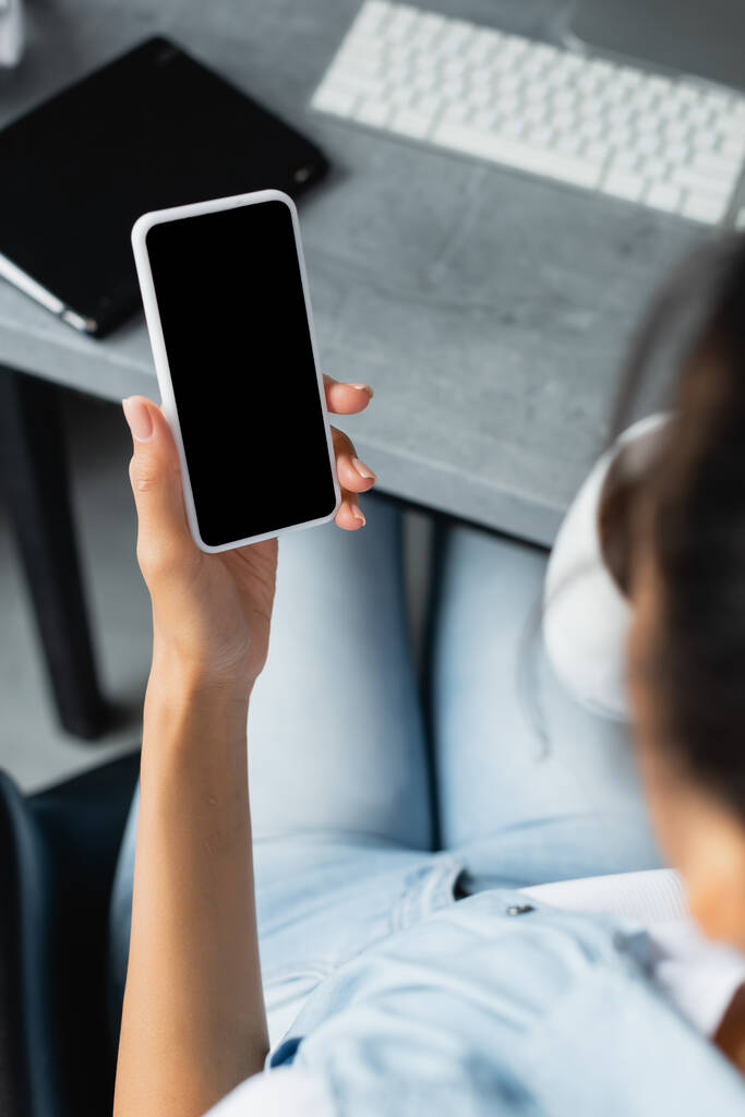 vista ritagliata di donna afro-americana con smartphone in mano con schermo bianco, primo piano sfocato - Foto, immagini