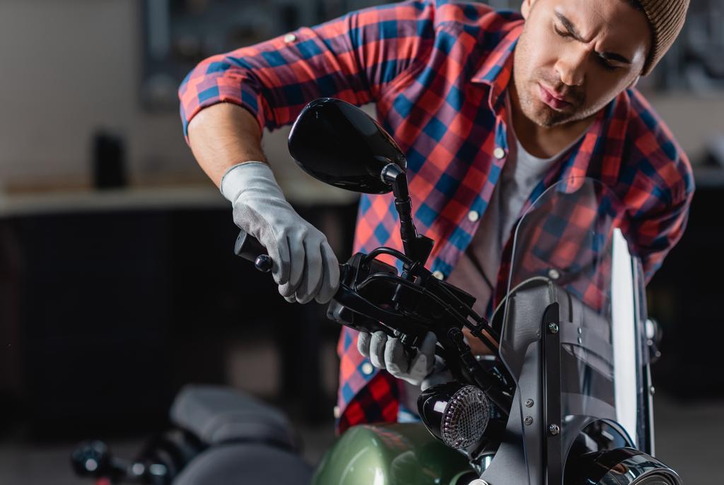 nuori mekaanikko, joka tarkistaa moottoripyörän ohjaustangon jarrukahvan  - Valokuva, kuva