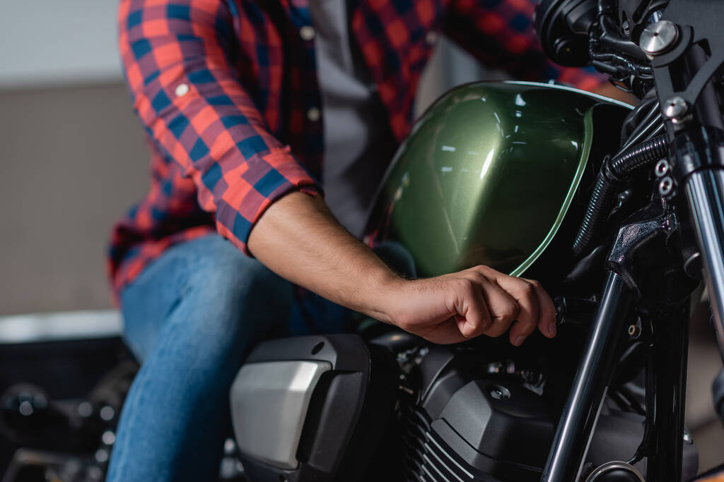 ořezaný pohled na mechanickou kontrolu motocyklů v dílně, rozmazané pozadí - Fotografie, Obrázek