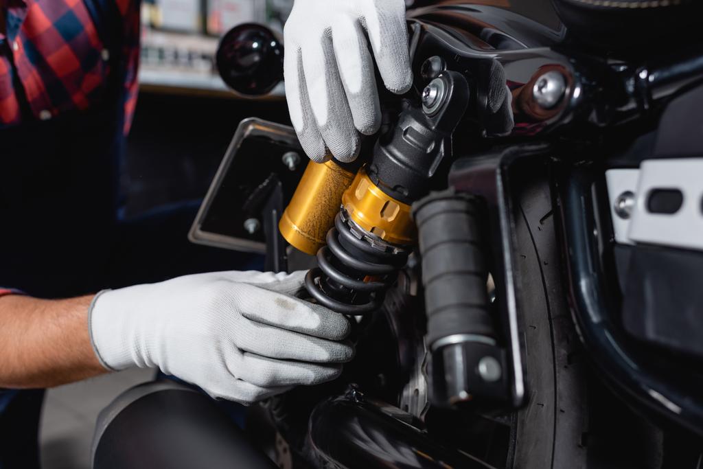 vista recortada de la comprobación mecánica amortiguador de la motocicleta en taller - Foto, imagen