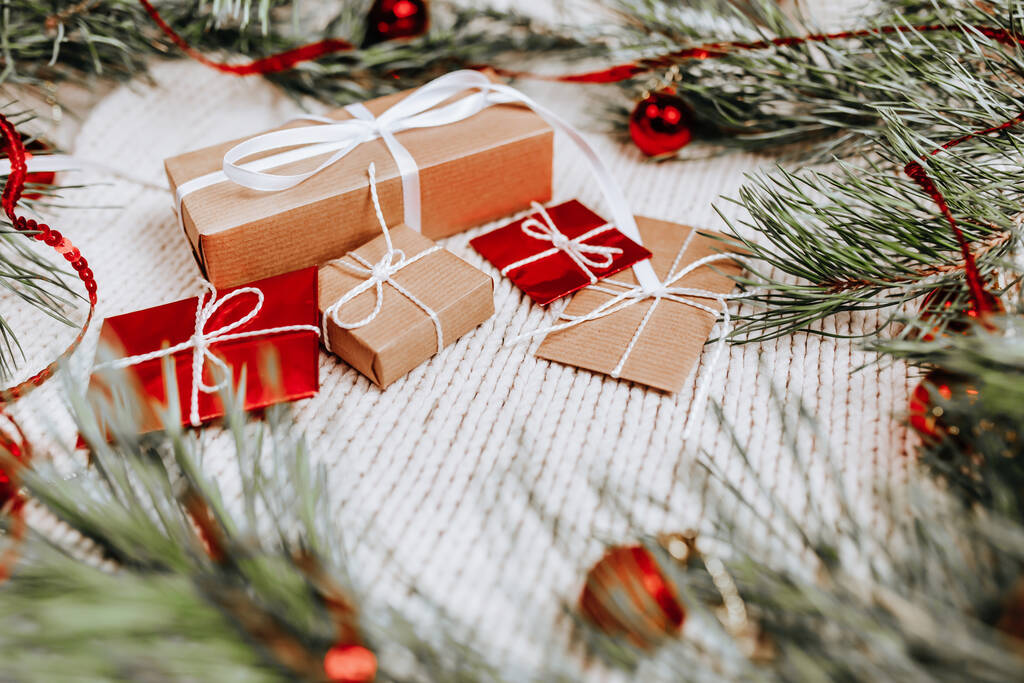 Neujahrsgeschenke auf gestricktem Hintergrund mit Weihnachtsbaum und Spielzeug - Foto, Bild