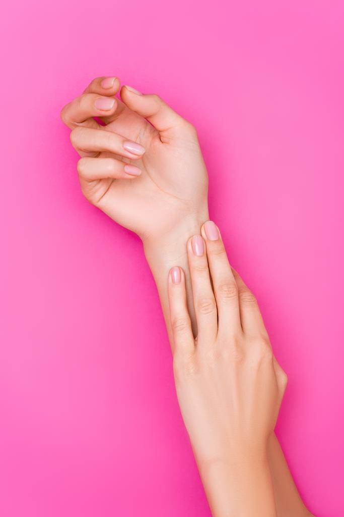 vista dall'alto di mani femminili curate con manicure pastello su sfondo rosa - Foto, immagini