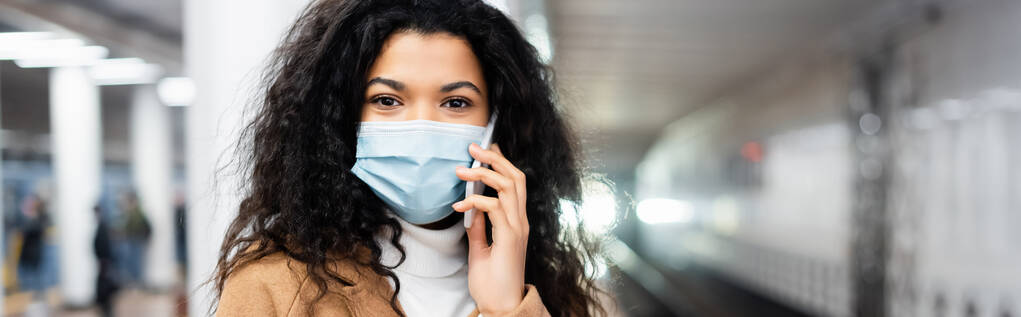 afro-amerikai nő orvosi maszk beszél okostelefon metró, banner - Fotó, kép
