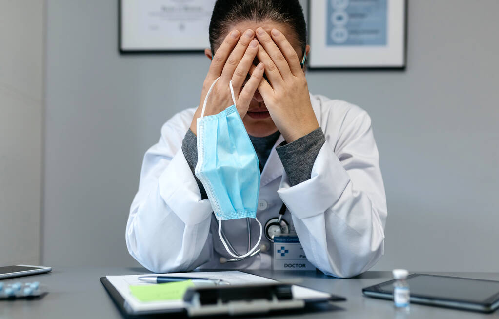 Ženský lékař s pandemickou únavou zakrývající její tvář - Fotografie, Obrázek