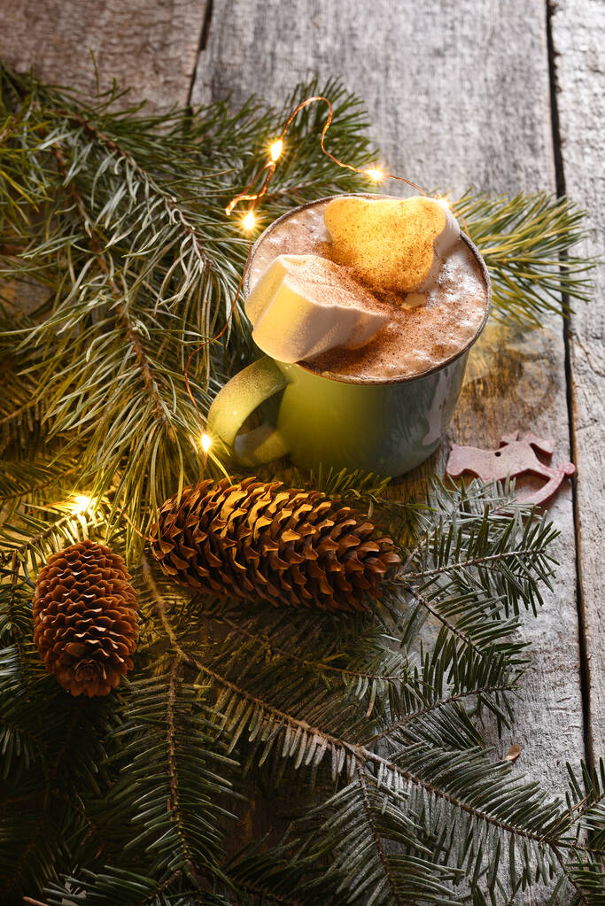 Кофейный напиток с зефиром и ветками рождественской елки с шишками. Новогодний фон. - Фото, изображение