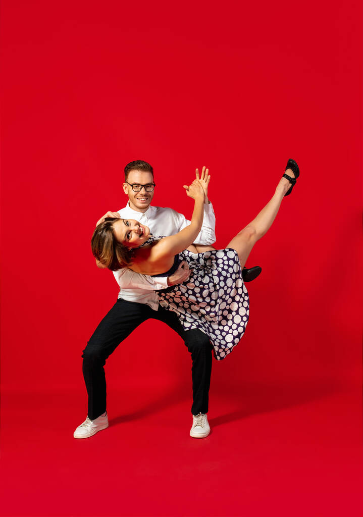 Vecchio stile giovane coppia che balla isolato su sfondo rosso - Foto, immagini