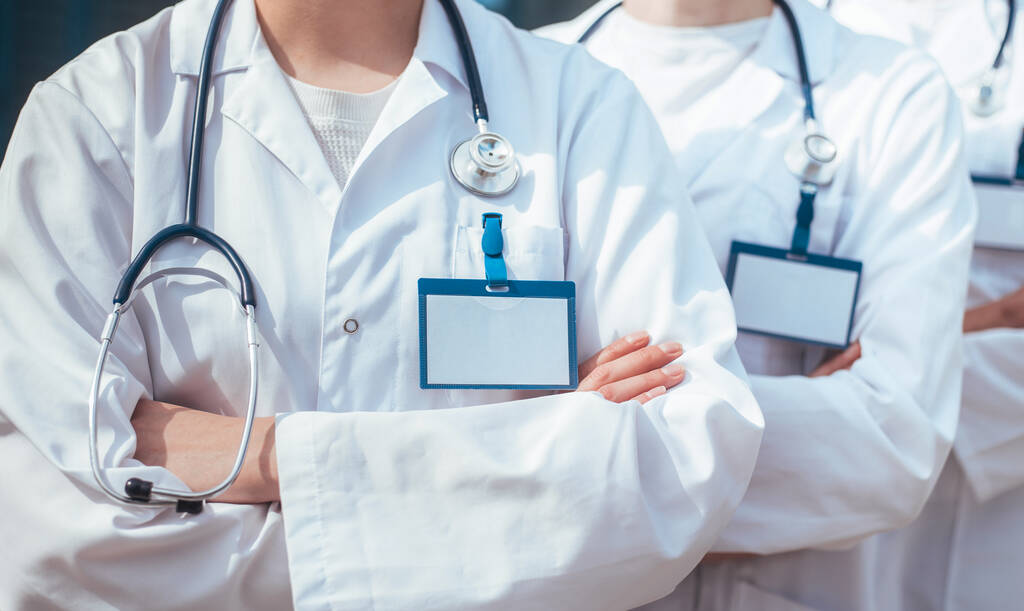 Fecha. grupo de médicos com crachás em branco de pé em uma fileira. - Foto, Imagem